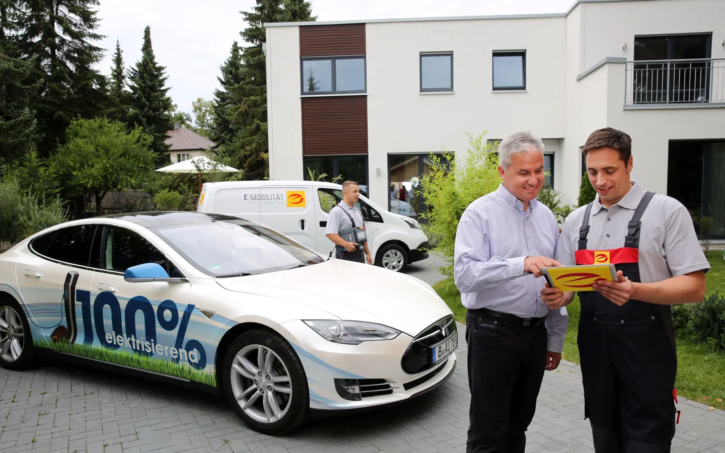 E-Mobilität - Mitarbeiter mit Kunden vor Elektrofahrzeugen 100% elektrisch &middot; ARNOLD Elektrotechnik